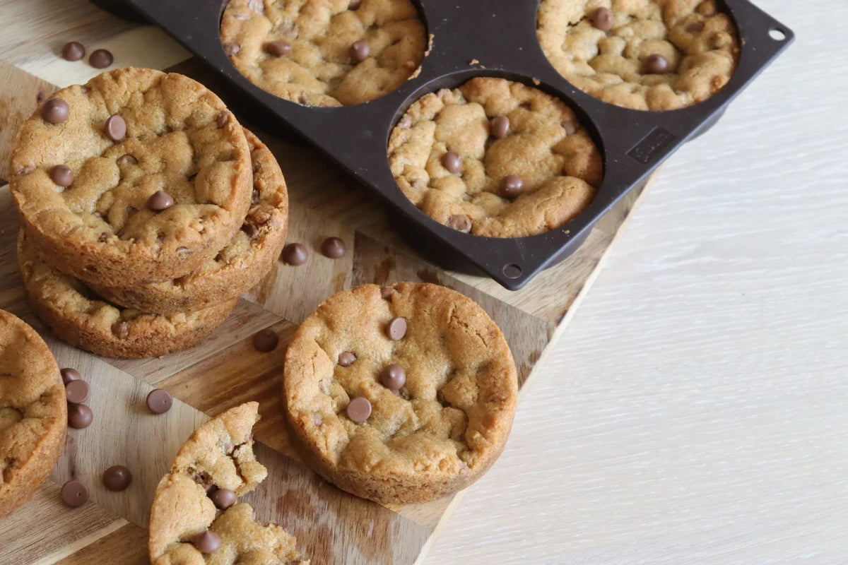 Deep dish cookies med lys sjokolade på et trebrett og i silikonform