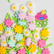 Nærbilde av kakestrøssel med blomsterformet konfetti og jimmies i pastellfarger