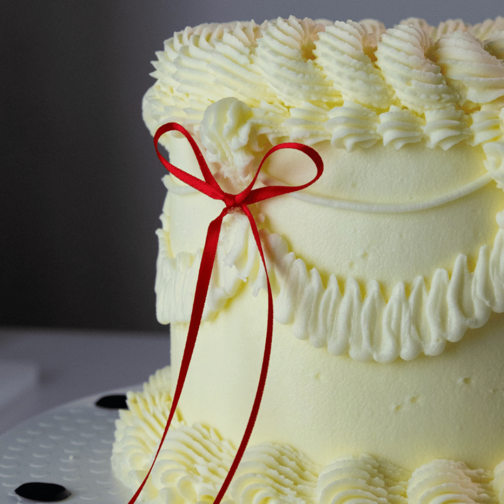 Vintage-kake dekorert med røde satengsløyfer fra PME