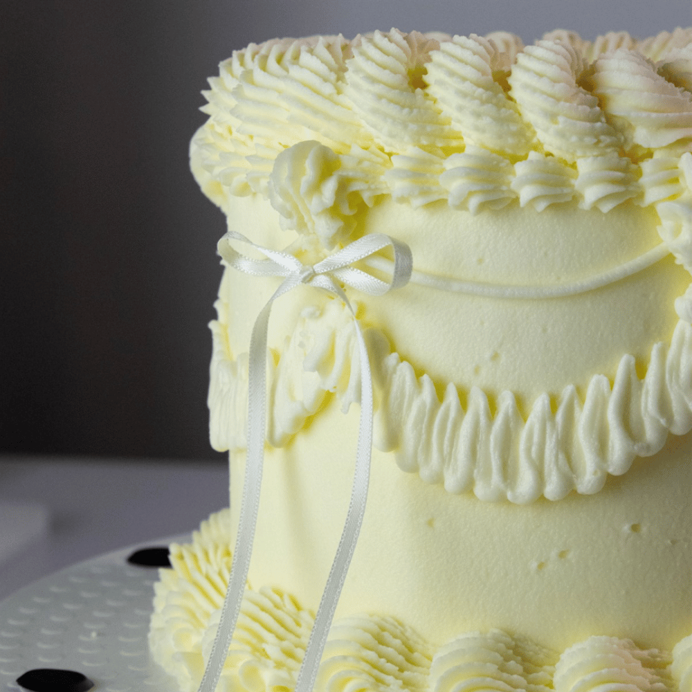 Vintage-kake dekorert med hvite satengsløyfer fra PME – elegant og tidløs stil