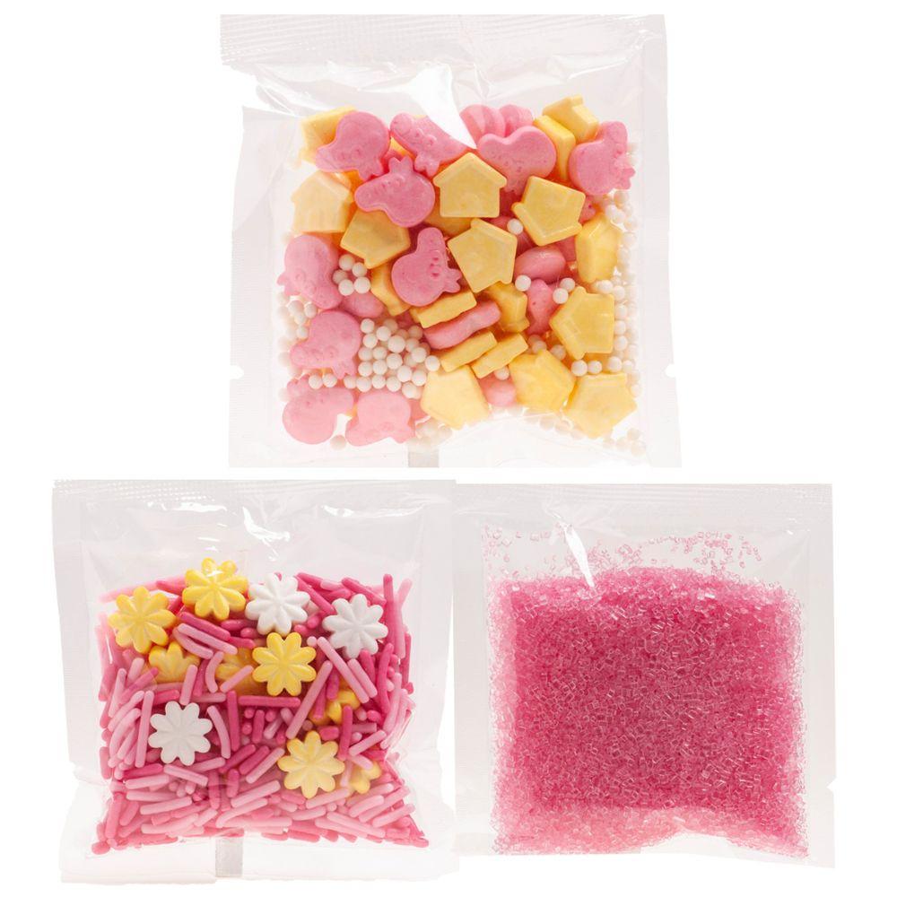Tre poser med Peppa Gris-kakestrø i rosa, gult og hvitt – sukkerfigurer og krystaller