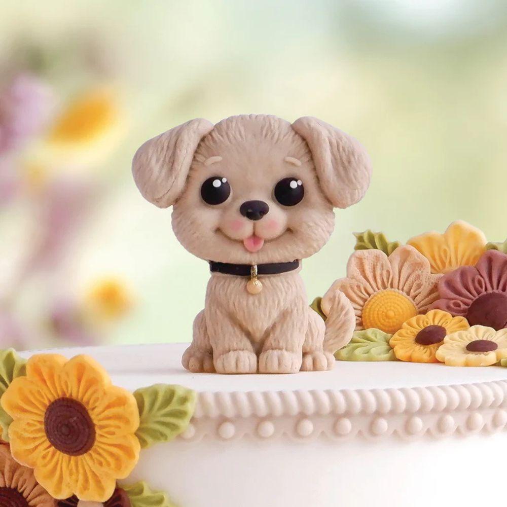 Ferdig stående hundefigur i fondant med krage og detaljer, på hvit kake med solsikker