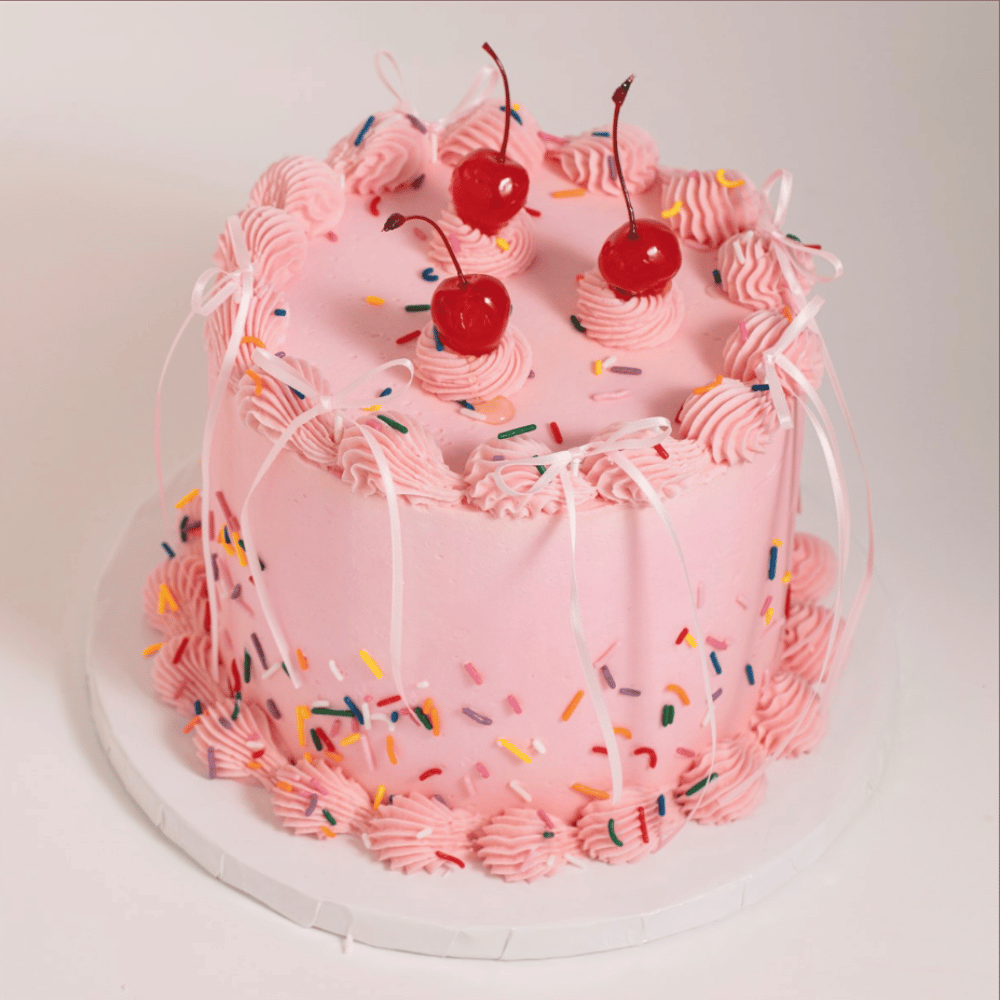 Ferdig knyttet satengsløyfe i lyserosa på vintage kake