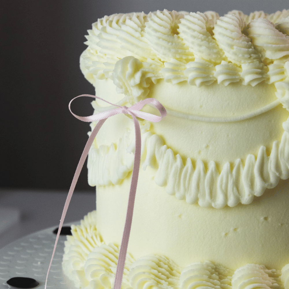 Vintage-kake dekorert med lyserosa satengsløyfer fra PME