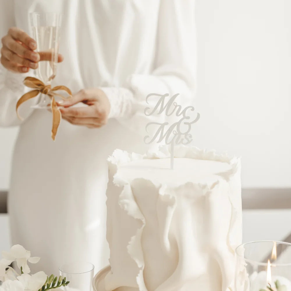 Hvit kaketopp Mr & Mrs plassert på bryllupskake