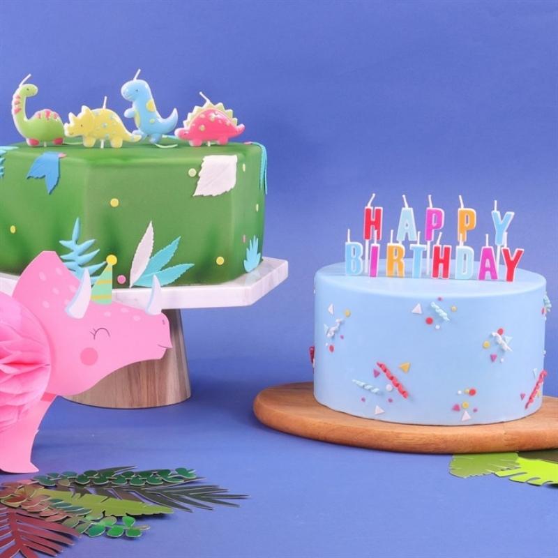PME kake med 4 kakelys av apatasauros, stegosaurus, t-rex og triceratops.