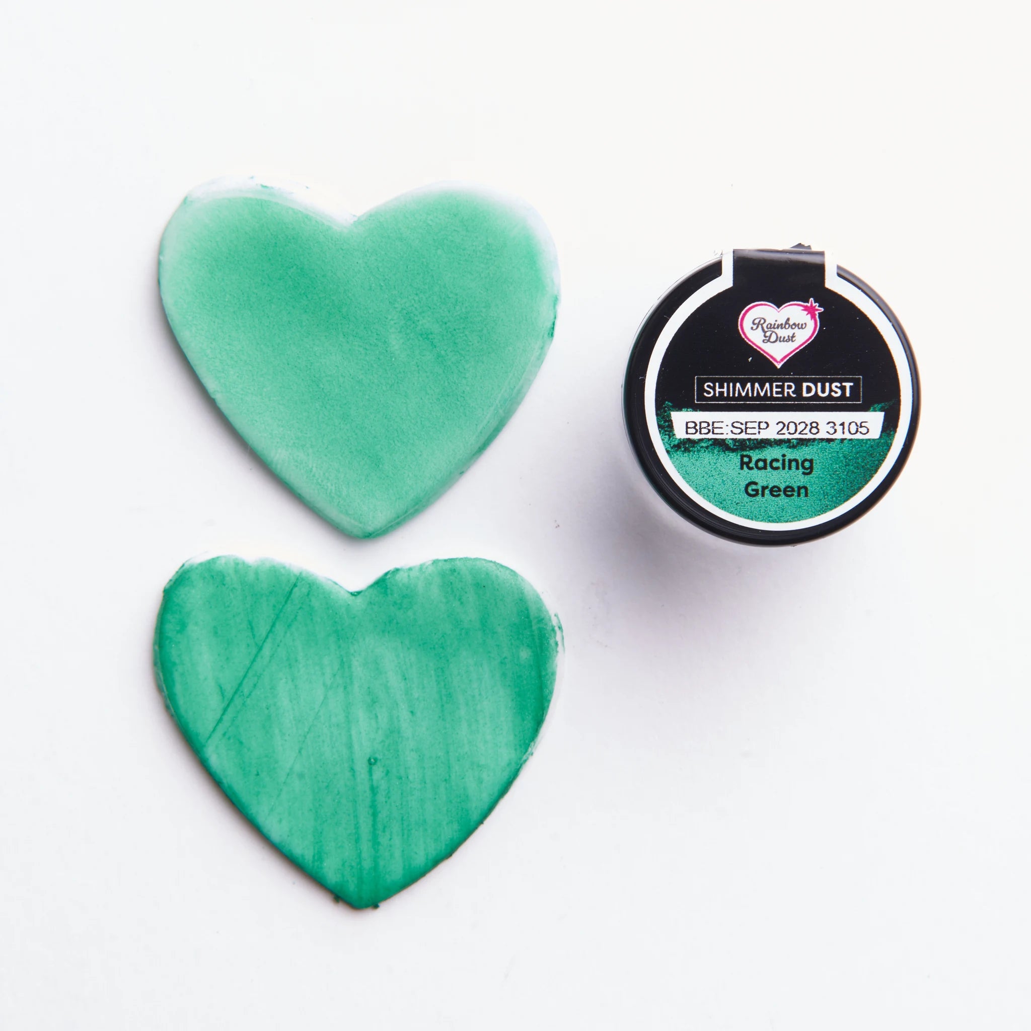 Shimmer Dust Racing Green påført tørt og blandet med alkohol – to hjerteformede prøveflater viser forskjell i intensitet