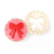 FMM Dobbelutstikker Sløyfe/sirkel  Utstikker fra FMM som egner seg spesielt godt til å lage dekor til cupcakes eller muffins. Med denne ustikkeren kan du våde lage en sirkel med bølgete kant og sløyfe, begge deler med en enkelt utstikker. Perfekt til å dekorere en cupcake.  
 Størrelse: Sirkelen er ca 6cm, og sløyfen ca 5cm. 
 Engelsk instruksjoner følger med. 