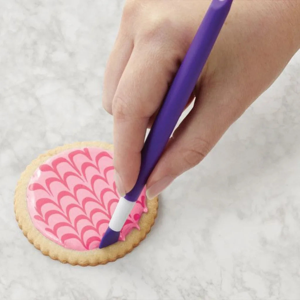 Wilton detaljverktøy brukt til mønster i rosa royal icing